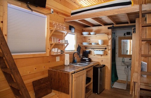 Meeker House | Adorable Tiny Home with two lofts. Both are accessible by ladder. One has a Queen mattress and the other has a Twin mattress. Home also contains a folding Full futon on main level. Sleeps: 4