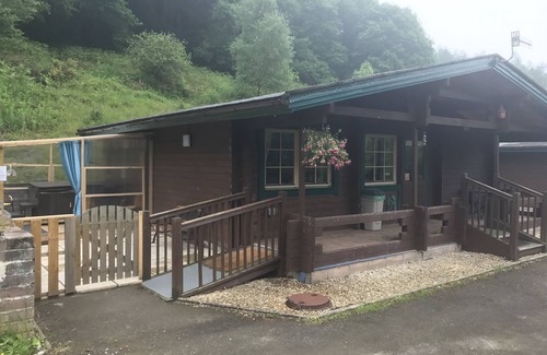 Ynysddu Cabin | Finnish Holiday Lodges, set in wooded hillside, with mountain and stream views