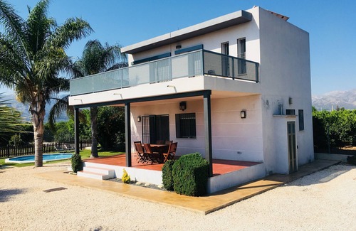 Pego Ski Chalet | house among orange trees .