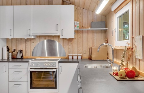 Vorupør House | On a hilly natural plot surrounded by trees, lies this beautiful wooden vacation home.