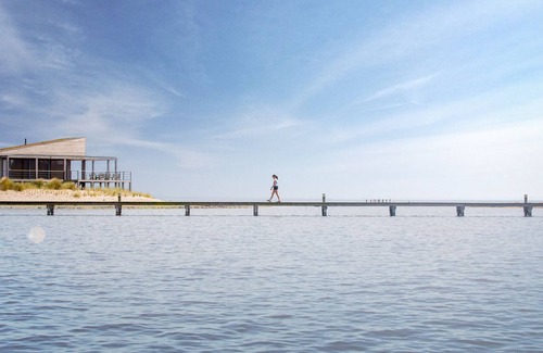 Ouddorp Cabin | Spacious beach villa with private swimming jetty and a terrace on the water.
