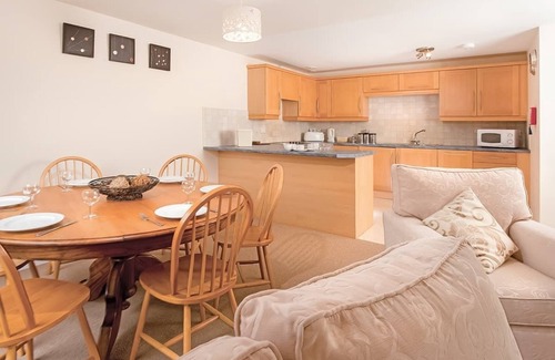 Chysauster Cottage | This bronze bungalow features an open kitchen, dining room, and living room.