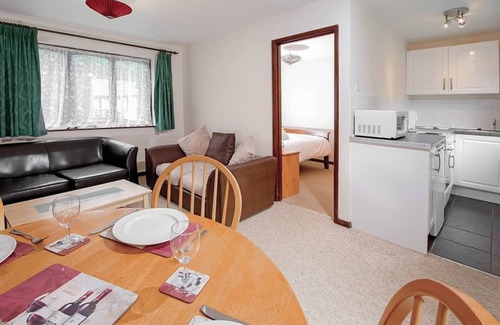 Chysauster Cottage | This bronze bungalow features an open kitchen, dining room, and living room.