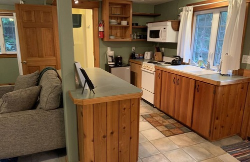 Ashford Cabin | This romantic cabin at Mt. Rainier is a one room cabin with private hot tub right on Copper Creek. It has a queen bed and a queen Murphy bed. Walk to Copper Creek Restaurant. Beautiful woodland setting.