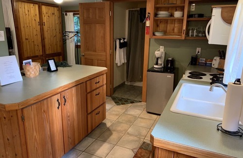 Ashford Cabin | This romantic cabin at Mt. Rainier is a one room cabin with private hot tub right on Copper Creek. It has a queen bed and a queen Murphy bed. Walk to Copper Creek Restaurant. Beautiful woodland setting.