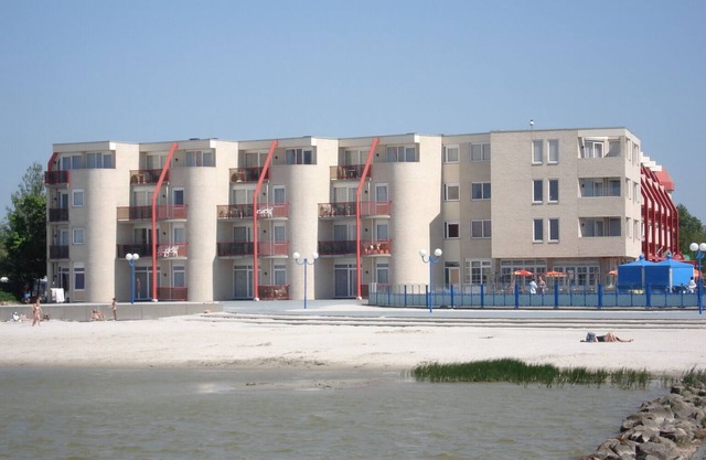 Apartment with a balcony or patio, a bathtub, and a private parking space right by the IJsselmeer at Beach Resort Makkum.