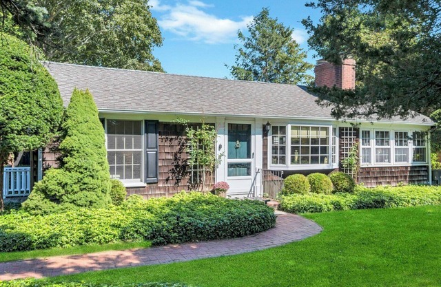 Beautiful cottage on meticulously maintained lawn, surrounded by.