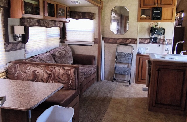 Cozy RV has 2 bedrooms, an outdoor kitchen with a grill & fridge