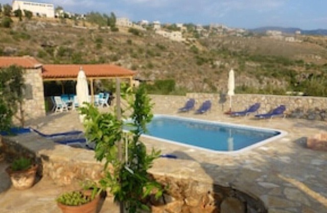 Stort gresk stenhus med svømmebasseng og romslige uteområder.