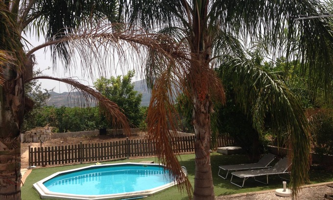 Pego Ski Chalet | house among orange trees .