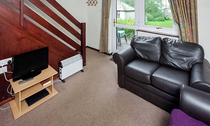 Chysauster Cottage | This bronze bungalow features an open kitchen, dining room, and living room.